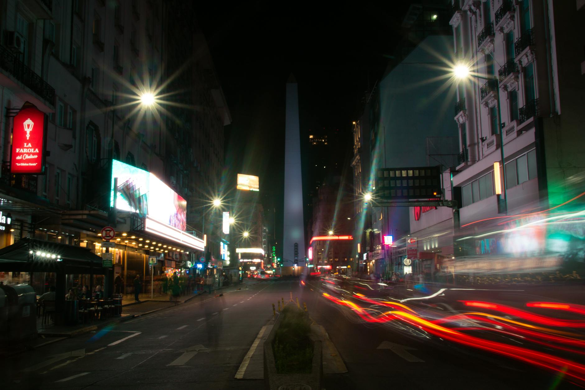 Nocne Buenos Aires z Obeliskiem i kolorowymi smugami świateł ulicznych
