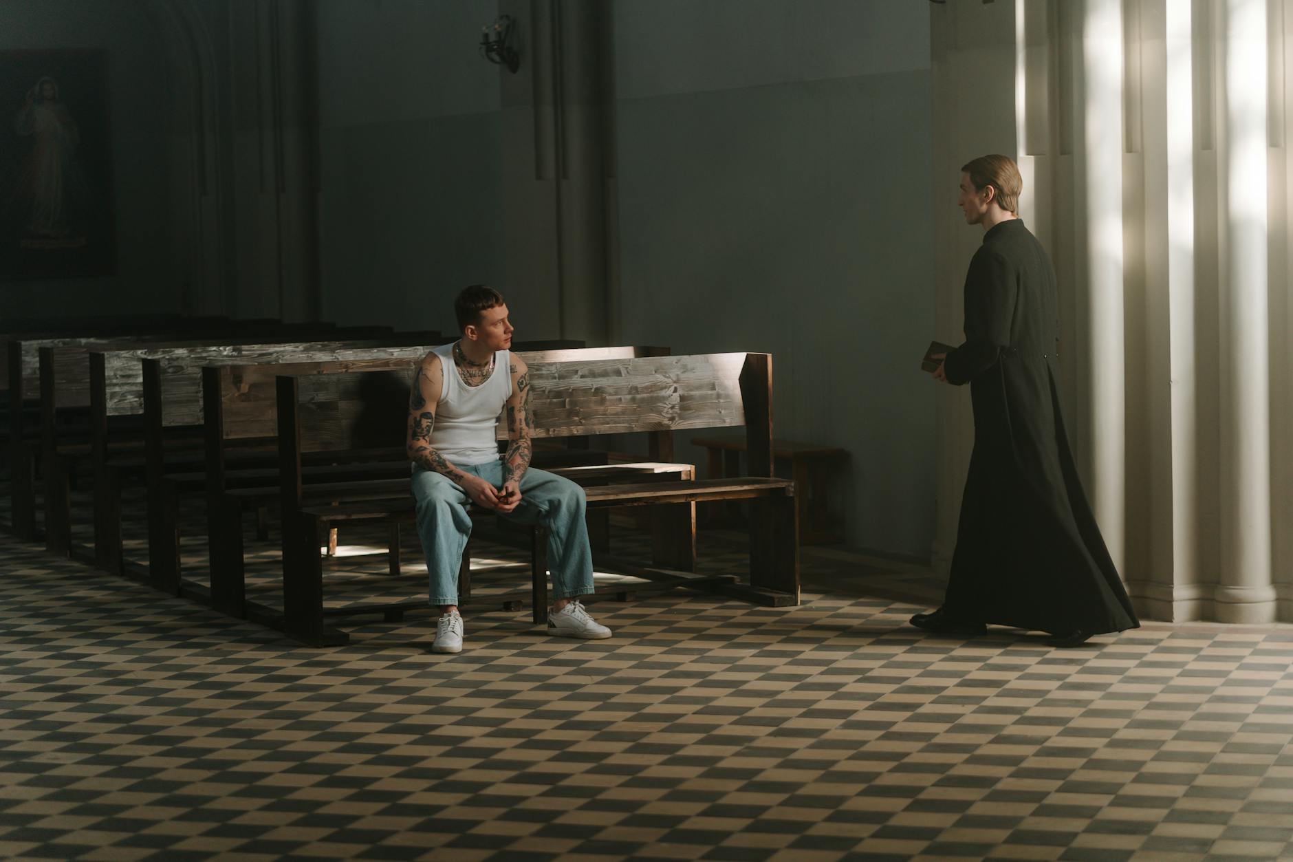 Tatuażysta rozmawia z księdzem w kościele przed spowiedzią