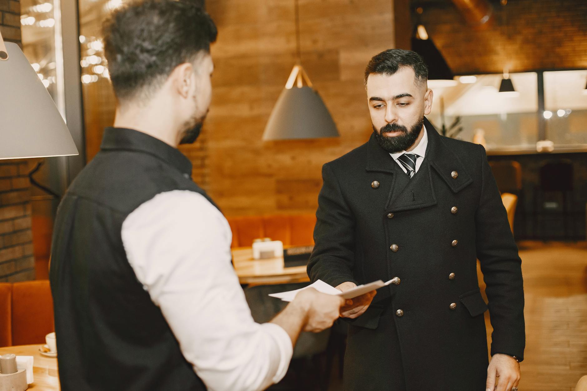 Kelner w amerykańskiej restauracji podaje menu siedzącemu gościowi
