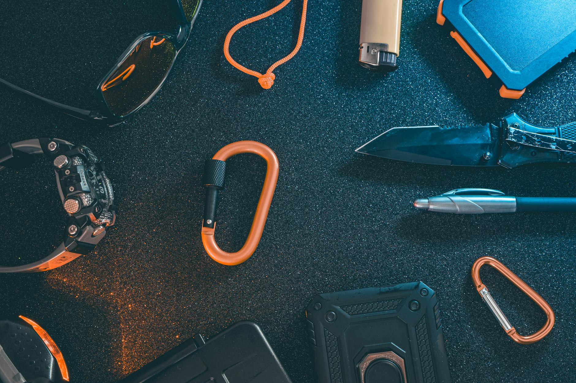 Minimalistyczny zestaw EDC z outdoorowym sprzętem ułożony na płaskiej powierzchn