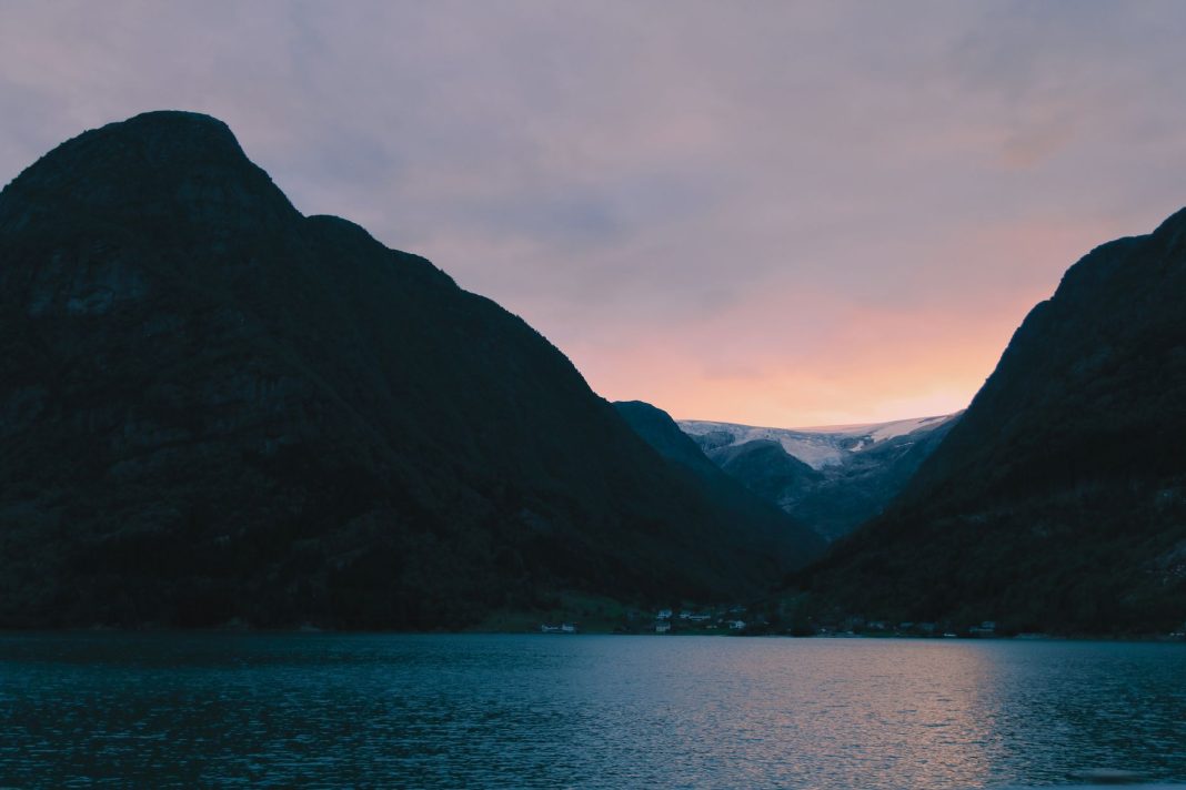 Fiord w Norwegii o zachodzie słońca na tle strzelistych gór Fiord w Norwegii o zachodzie słońca na tle strzelistych gór
