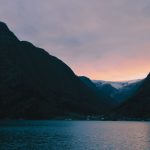 Fiord w Norwegii o zachodzie słońca na tle strzelistych gór