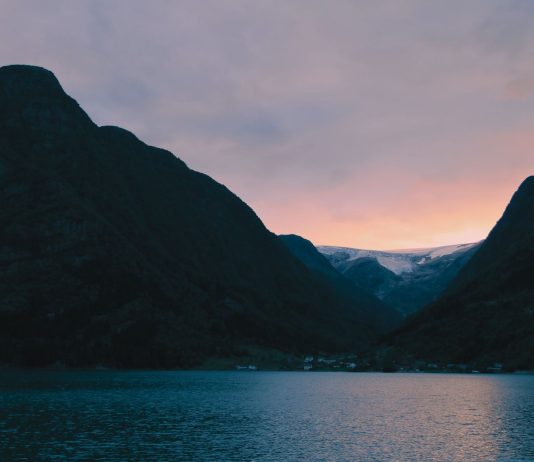 Fiord w Norwegii o zachodzie słońca na tle strzelistych gór