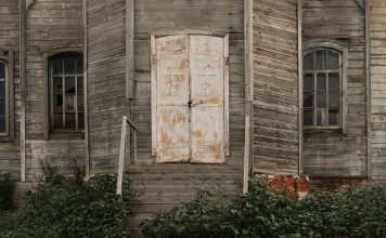Najpiękniejsze drewniane cerkwie i kościoły w Polsce, które przeniosą cię w czasie i historii Zbliżenie na opuszczony drewniany kościół ze starymi drzwiami