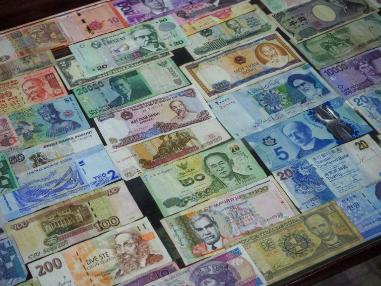 Kolorowe banknoty z różnych krajów ułożone w rzędzie na stole