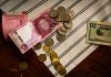 Peruwiańskie banknoty, dolary i monety na pasiastym tle