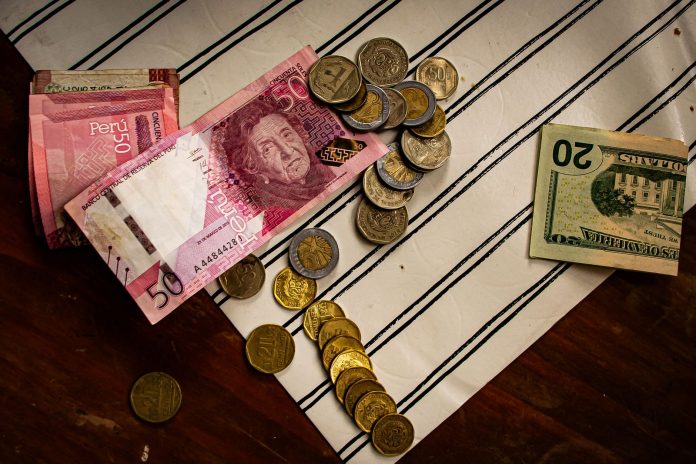 Peruwiańskie banknoty, dolary i monety na pasiastym tle Peruwiańskie banknoty, dolary i monety na pasiastym tle